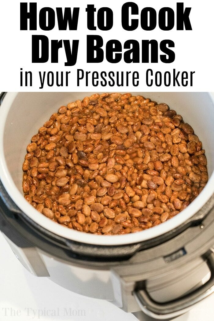 An overhead view showcases cooked brown pinto beans inside a pressure cooker. Text at the top reads, "How to Cook Dry Beans in your Pressure Cooker." The pinto beans appear fully cooked, filling the cooker to perfection.